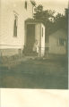 Young woman sitting on steps to house, Iowa, 1900s