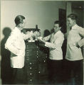 Dental students talking abour a model of teeth, The University of Iowa, 1940s