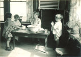Small children washing and drying dishes, The University of Iowa, 1920s