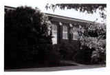 The front (north) staircase entrance to State Gymnasium is framed by trees