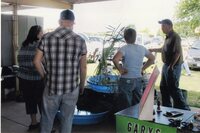 2008  Fair Booth worker Jay Jemison looks at plants in water displays with others.
