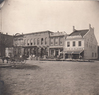 0126 West side of square with stores and a horse and wagon in the street