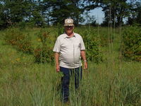 Unidentified farmer on his farmland with family