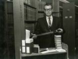 Warren B. Kuhn showing microfilm and book storing methods, 1967