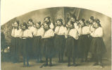 Dancing girls resting cheeks on tambourines, Roland, Iowa, 1910s