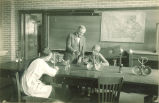 Instructor supervising students' lab experiment, The University of Iowa, 1920s?