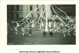 Women in costume dancing with a maypole on the Pentacrest lawn, The University of Iowa, June 1924