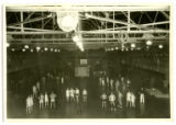 Basketball players gathered on the court in State Gymnasium