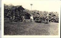 George A. Burden and Vidie Burden with push mower by Four Mounds well