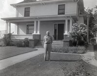Man stands in front of two story house