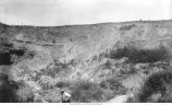Man at base of hill in Webster County, Iowa, late 1890s or early 1900s
