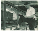 Engineering student recording data from water experiment in engineering laboratory, The University of Iowa, 1939
