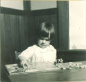 Child concentrates while assembling a puzzle, The University of Iowa, ca. 1920