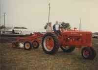 Norm Barker and Dr. Tom Bjorge sit on tractor at Plymouth County Fair in July 1996