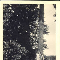 Unknown woman with large fish hanging over her shoulder