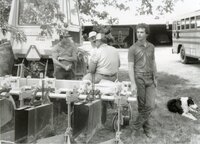 Men stand under tree during a meeting