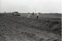 1979   William Baugh, Des Moines County soil conservation aid, holds a measuring tool in a field while two men watch
