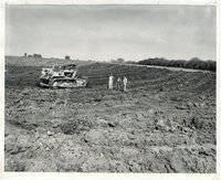 Men in bulldozed field