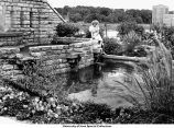 Woman with fountain near Iowa Memorial Union Pedestrian Bridge, Iowa City, Iowa, between 1936 and 1939