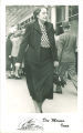 Woman with glasses walking away from a theater, Des Moines, Iowa, 1930s