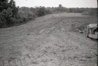 Dirt moved beside trees in field