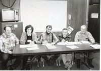 Five unidentified workers sit at table for meeting