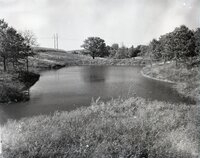 1963 - Pond surrounded by trees and water