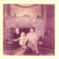 Frindy, John, Sr. and corgies sitting on fire place hearth 