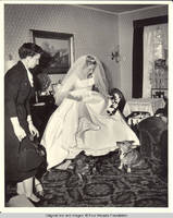 Unknown woman and Frindy lifting her skirts to corgies in parlor