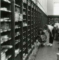 Two women are reading a newspaper in the Periodical Room.