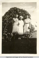 Three women by lilac bush