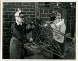 Two cadettes welding parts of the tail of a wrecked plane, 1943