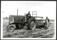 Men Pose with a Tractor in a Field 