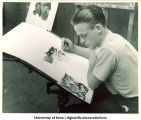 Artist Frank Dorsay designing war poster at War Art Workshop, The University of Iowa, 1942-43
