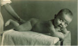 Smiling baby lying on stomach, The University of Iowa, 1920s