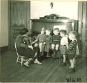 Children near  piano listening to a woman play violin, The University of Iowa, January 12, 1938