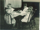 Children sitting at small dinner table, The University of Iowa, 1920s