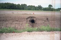 Hole in dirt wall by road