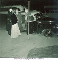 Couple standing by taxi, The University of Iowa, 1940s