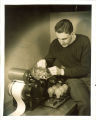 Engineering student adjusting an electric machine with roll of paper, The University of Iowa, 1939
