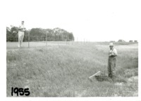Mike Moul and Melvin Bird inspecting pipe drop inlet, 1955