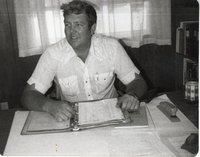 Fred Hainline Reads Material in Notebook