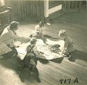 Woman showing children a poster about trains, The University of Iowa, January 12, 1938