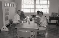 Four men sit at a table at an office meeting