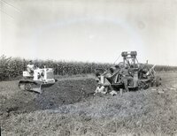 Two men in field with bulldozer and scraper
