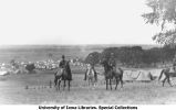 Cadets riding horses at camp near tents, The University of Iowa, 1912