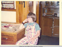 John, Jr. sitting by butchers block table in kitchen