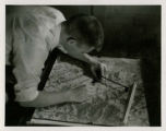 Student using tools on a relief map, 1957