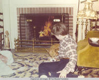 John, Jr. and corgy playing cards in front of fire place