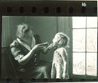 Woman looks in a small girl's mouth using a flashlight, The University of Iowa, May 10, 1941